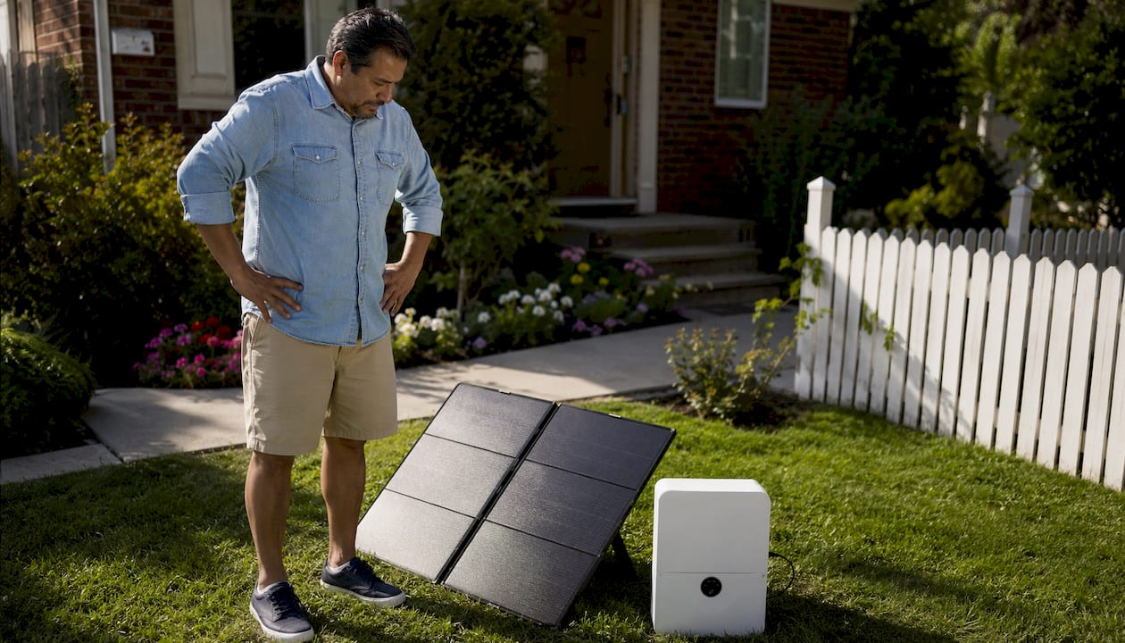 Man inspecting portable solar generator outdoors