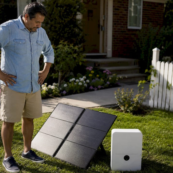 Man inspecting portable solar generator outdoors