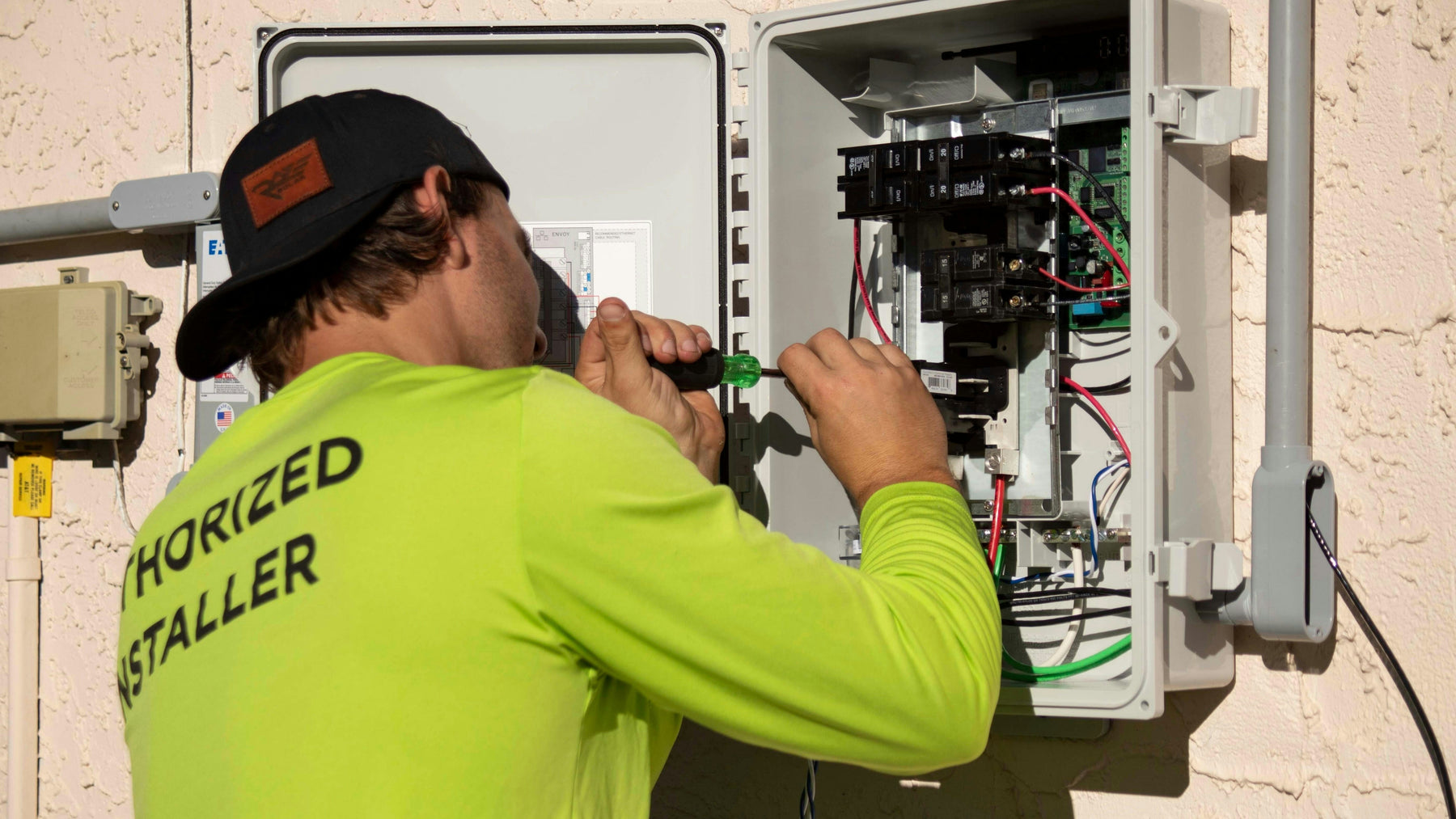 Authorized electrician installing residential electrical panel for EV charger project